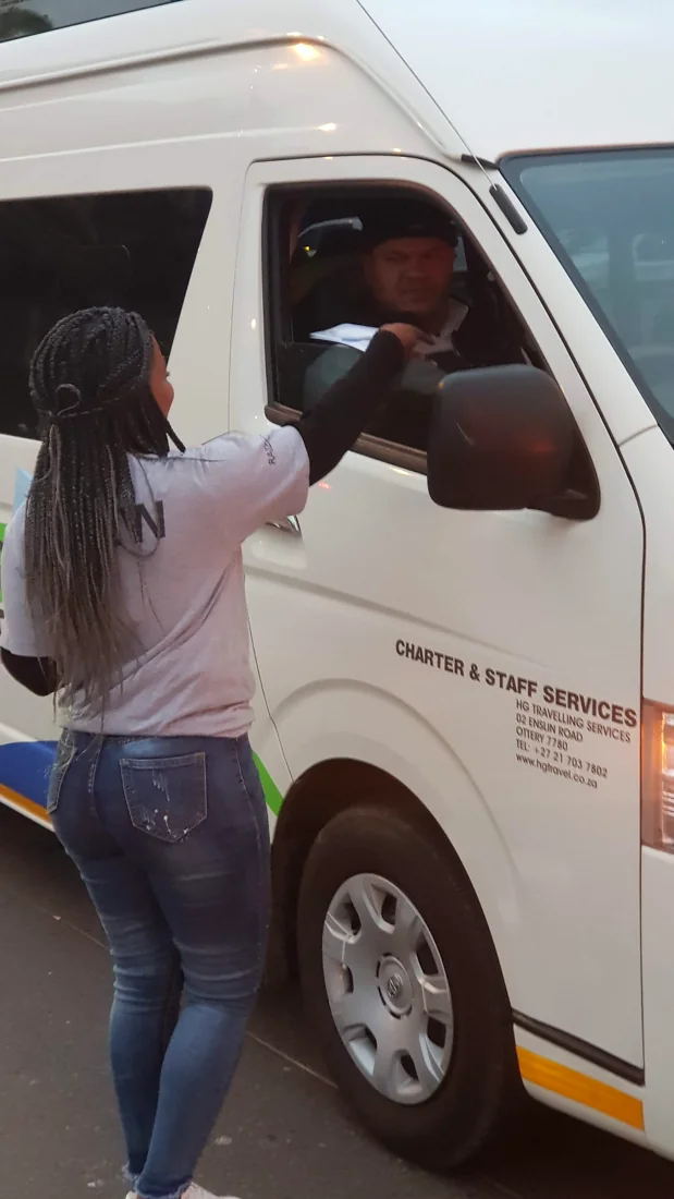 Promoter handing a flyer to a taxi driver