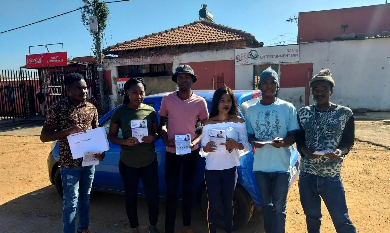 Field team standing with printed campaign material