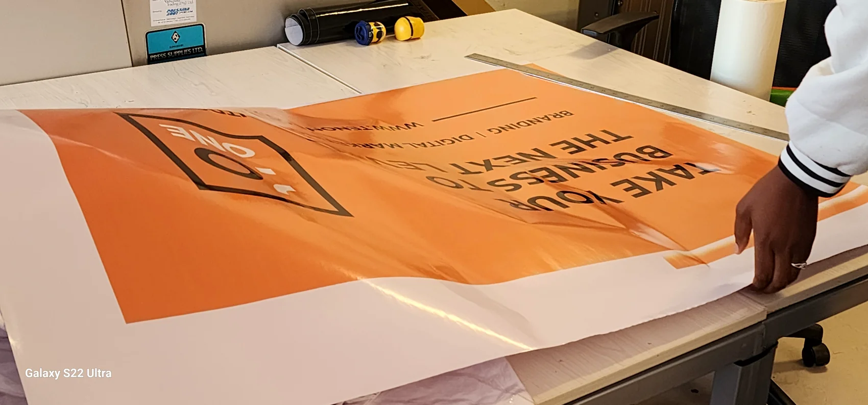 Large-format printed board being prepared on a work table