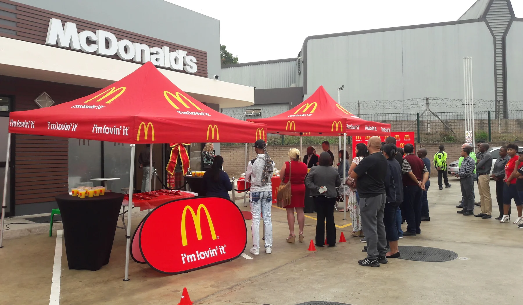 McDonald's and McCafe activation with branded tents and customers queueing outside a store
